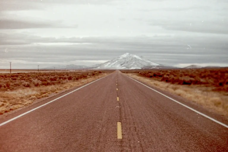 A road with a mountain in the background.